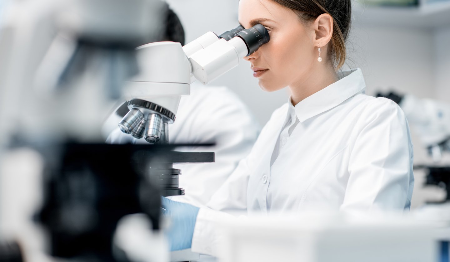 Naukowiec analizujący próbki pod mikroskopem w laboratorium badawczym.