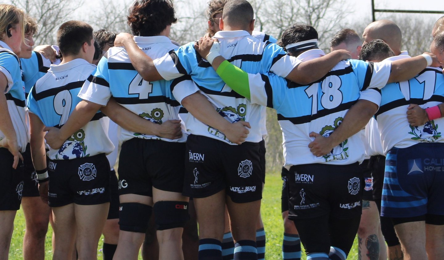 a group of people standing in a circle with rugby shorts