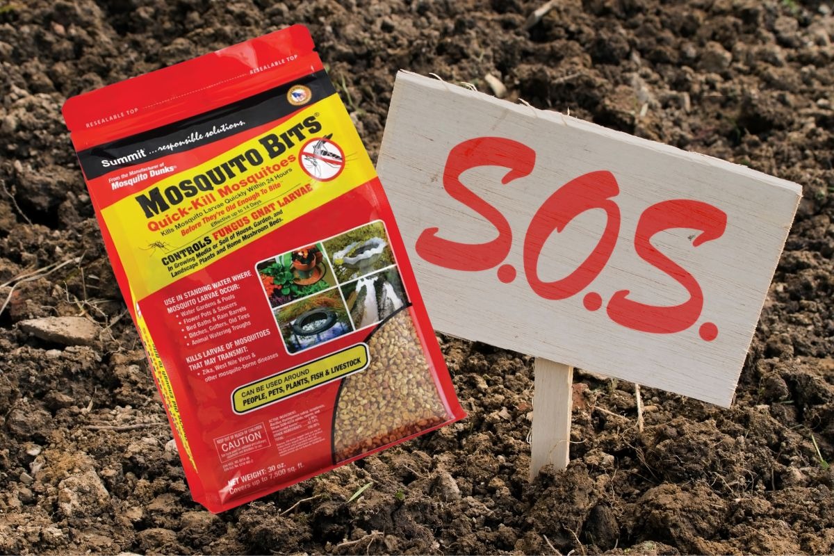 summit mosquito bits bag next to an sos sign in soil representing a fungus gnat infestation