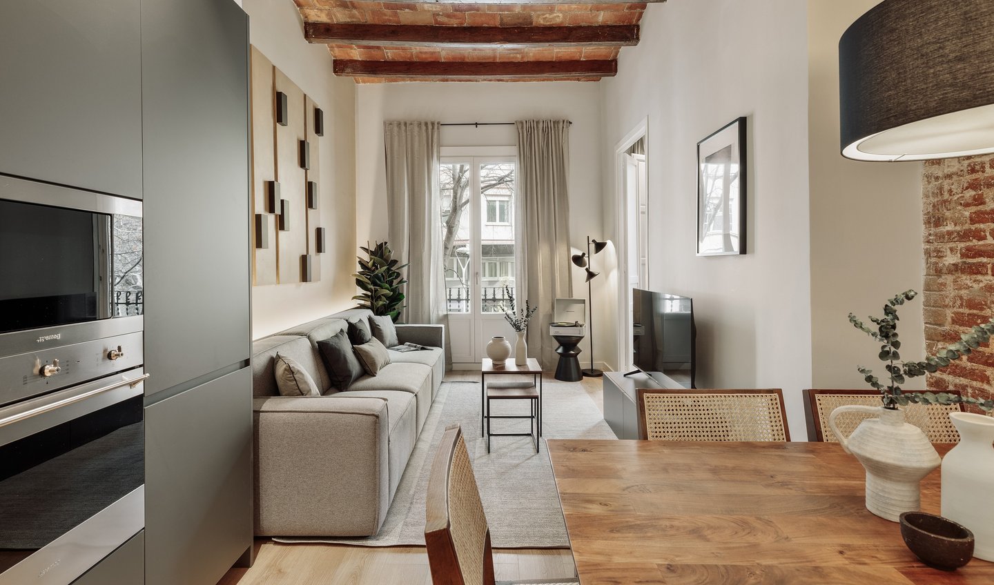 Living room with exposed brick ceiling, wood table and a mix of modern and rustic design