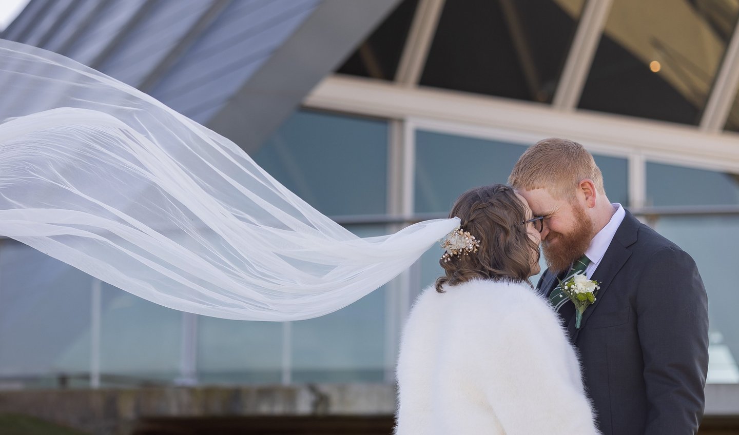 Bride and groom facing each other, her veil flowing behind on Canberra wedding day