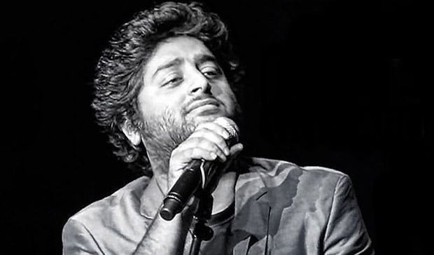 a man in a suit and tie is holding a microphone