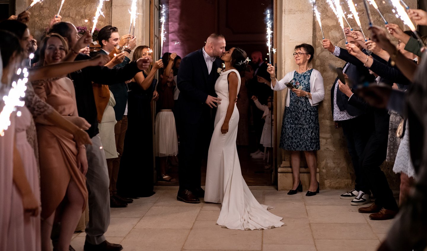 un couple de mariés s'embrassant devant leurs invités