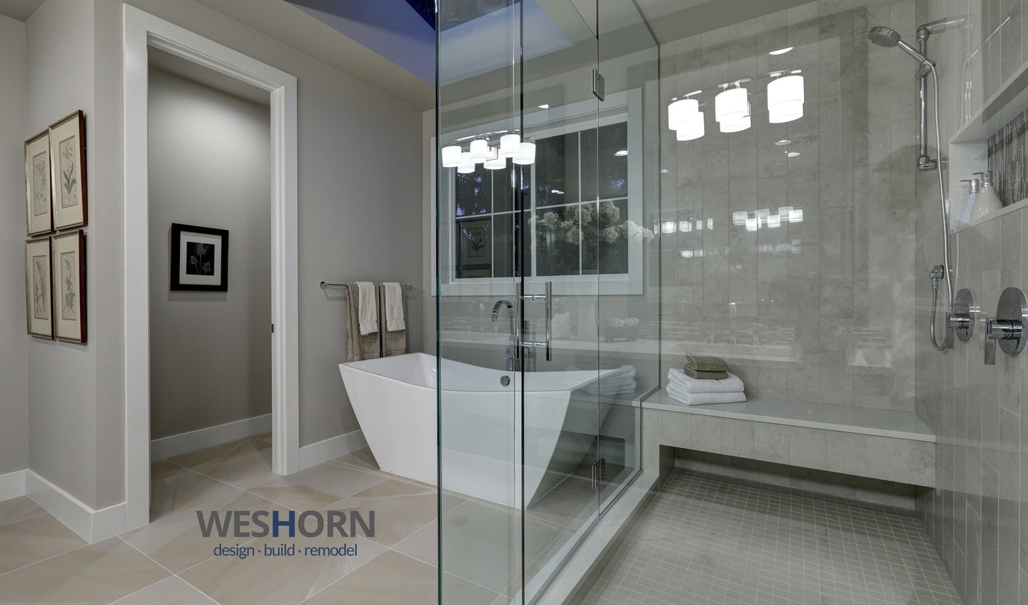 Modern luxury bathroom remodel featuring a freestanding soaking tub and glass walk-in shower with tile bench.