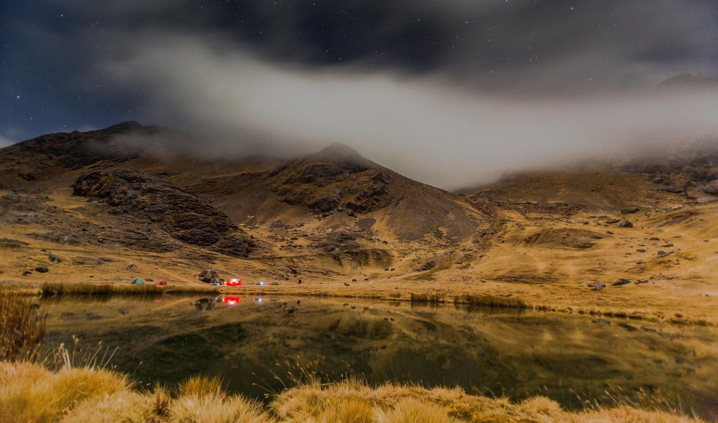 Photographer capturing sunrise reflection of Ausangate Mountain in Laguna Pucacocha, Peru