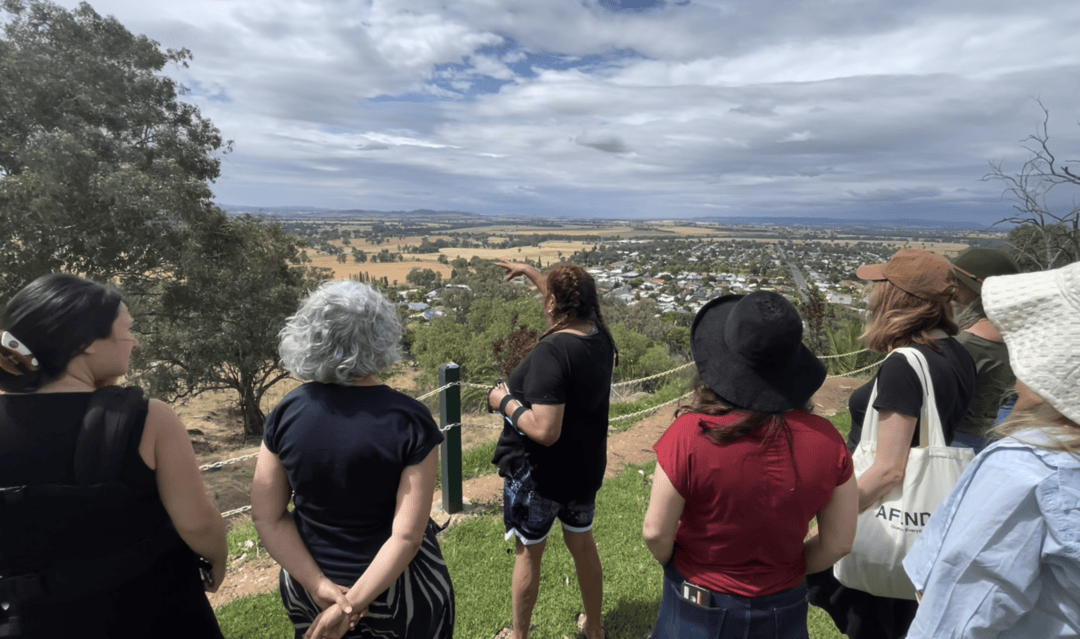 Women on a healing retreat overlooking a valley, connecting to Country in Regional New South Wales.