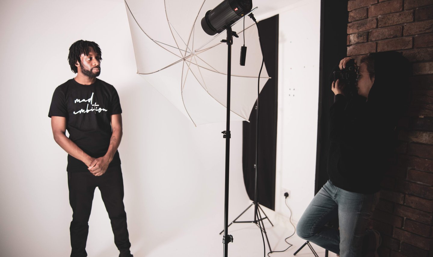 a man standing in front of a camera and a woman