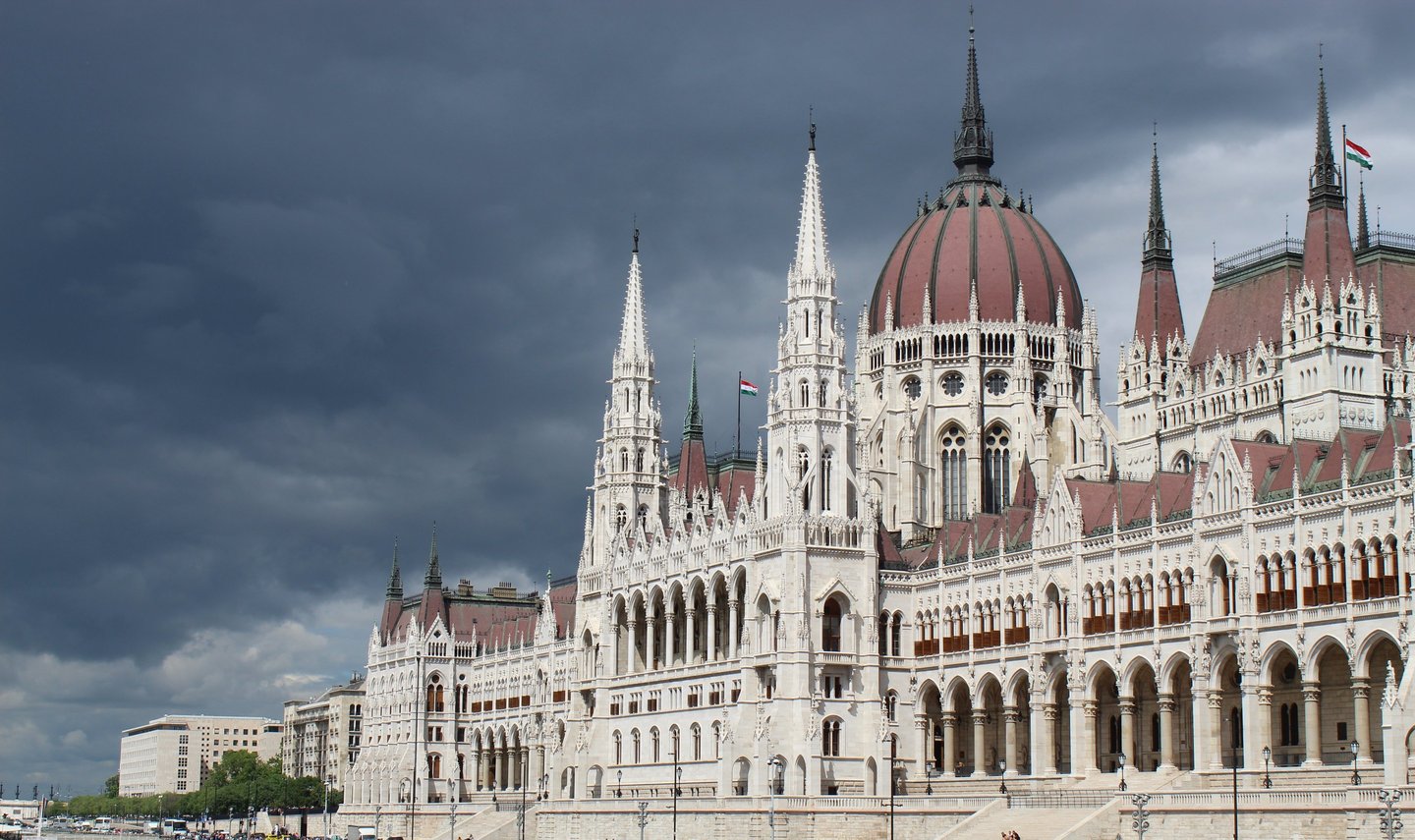 veduta del parlamento di budapest con sfondo di cielo plumbeo. contrasto netto di colori