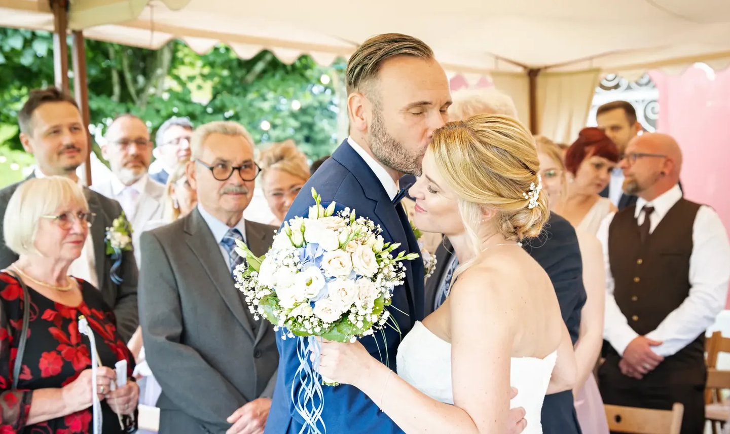 Brautpaar bei der Trauung am Möhnesee, emotionaler Kuss während der Hochzeit