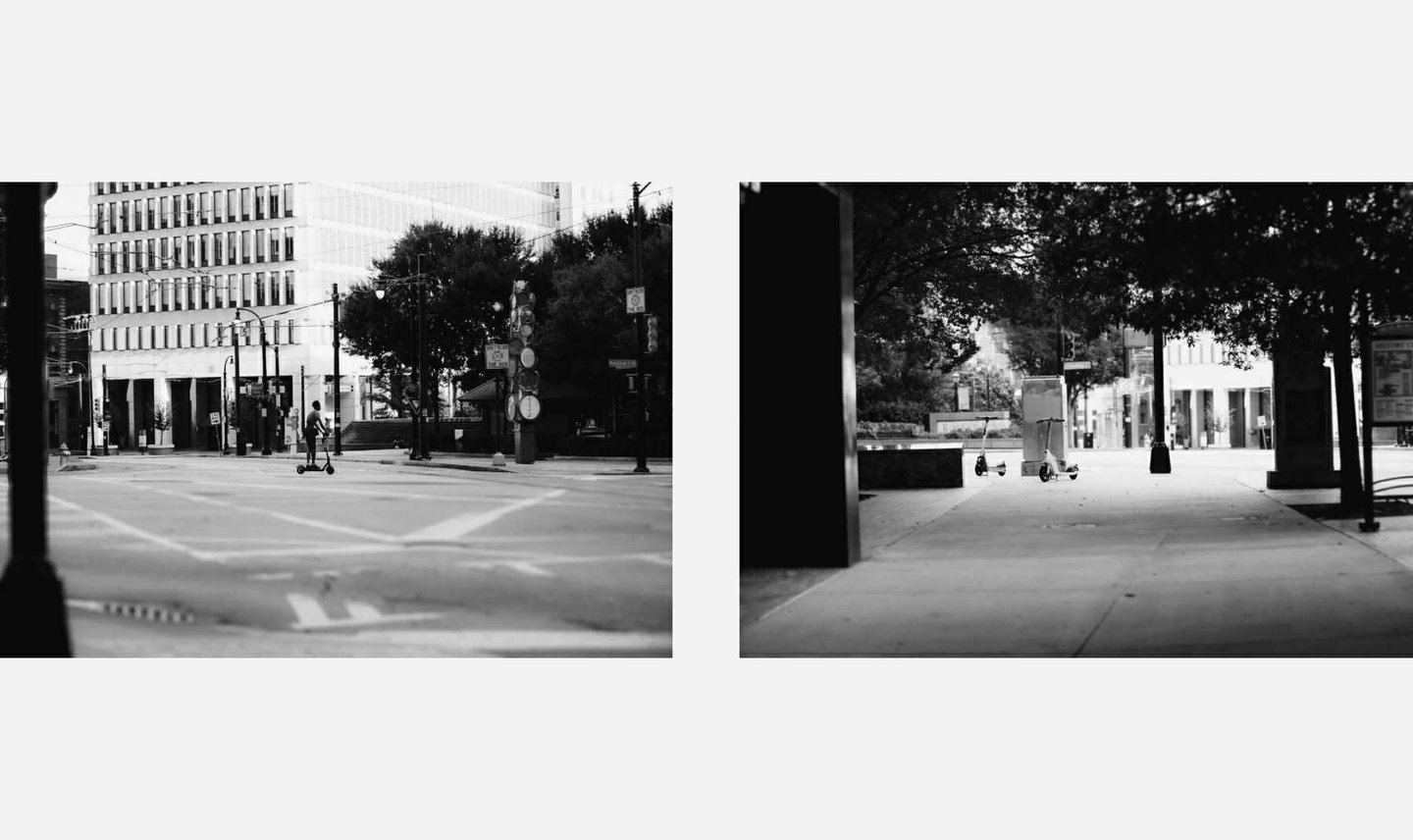 Black and white street photography featuring electric scooters parked on a quiet urban sidewalk.