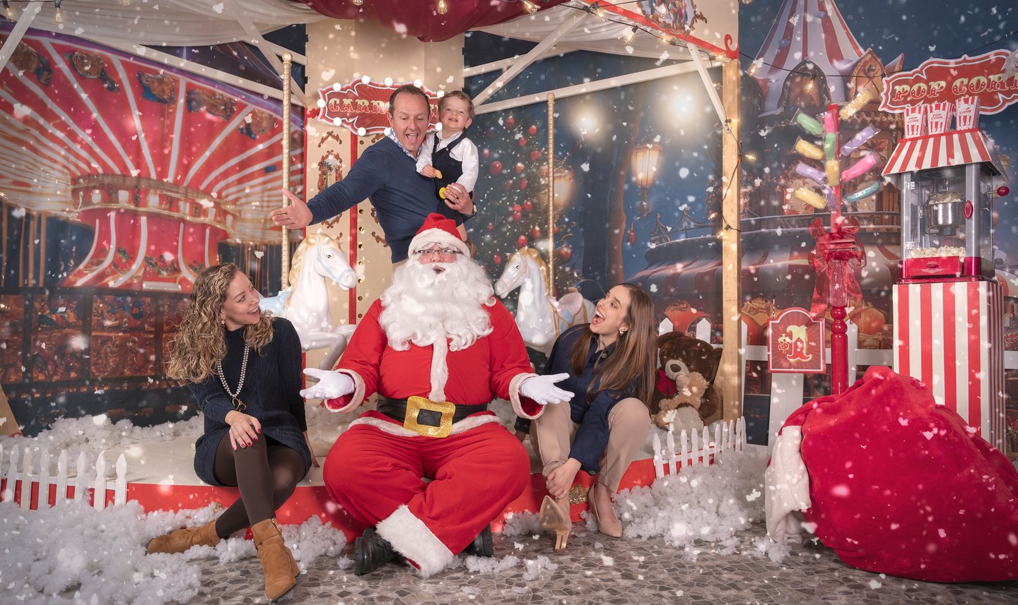 a man in a santa clause costume sitting on a carousel