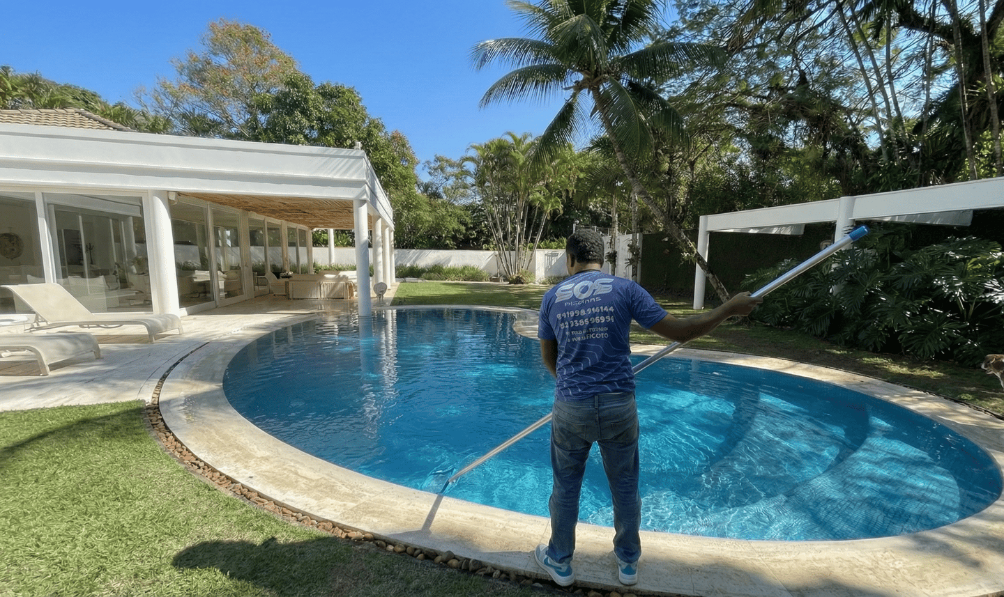 Piscineiro realizando limpeza e manutenção mensal de piscina em Jacarepaguá - S.O.S Piscinas.