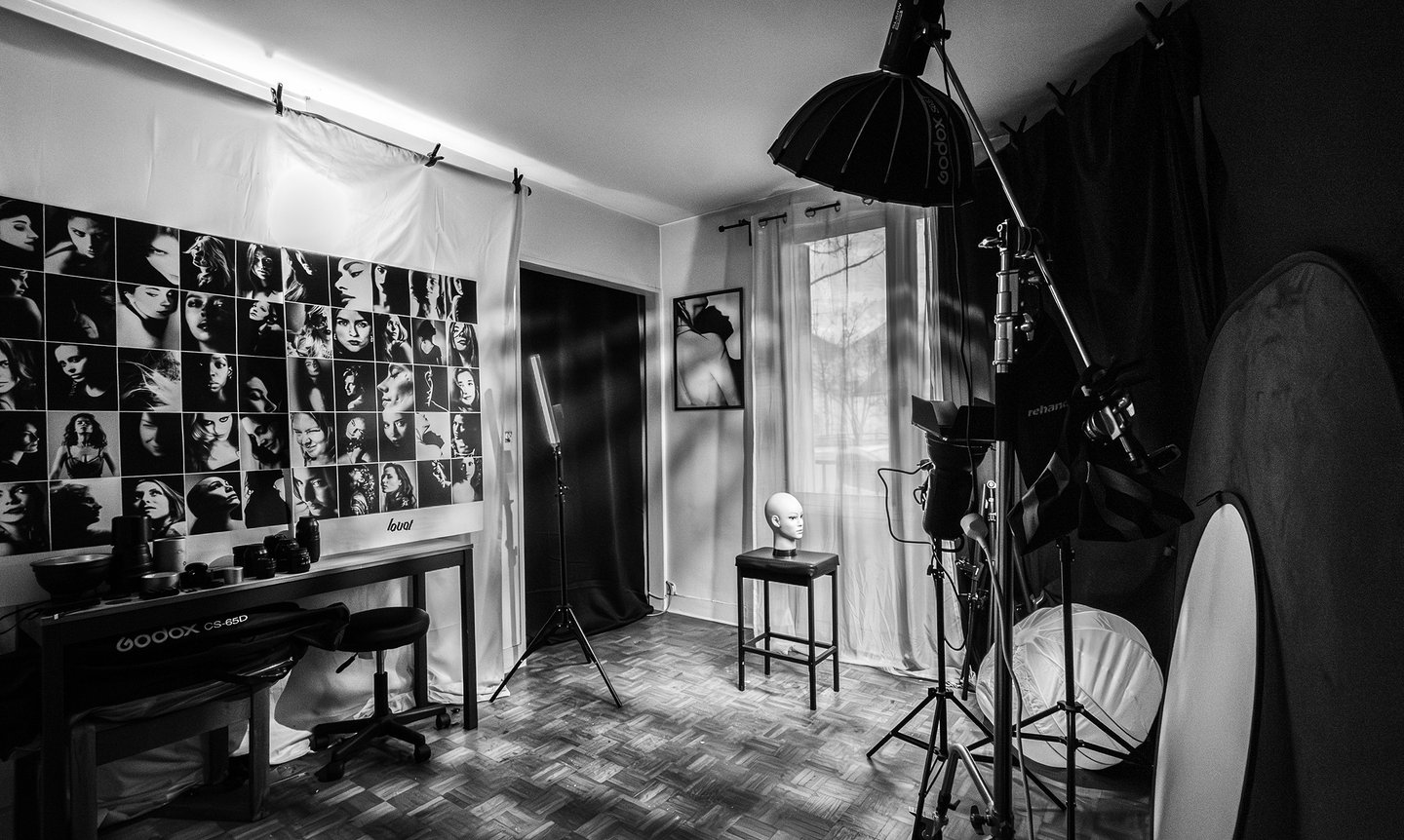 Black and white photo of a professioknal photography studio with Godox lights, reflectors, and drop.