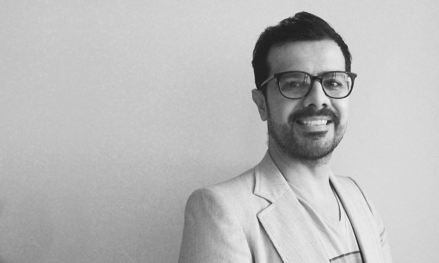 a man in a suit and glasses smiling