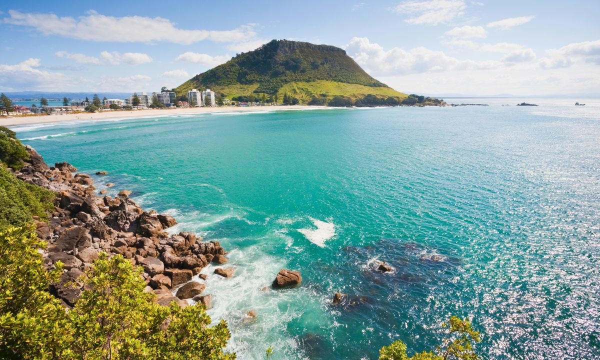 Vista do monte e do mar da Bay of Plenty em Tauranga, com a cidade ao fundo e céu claro.