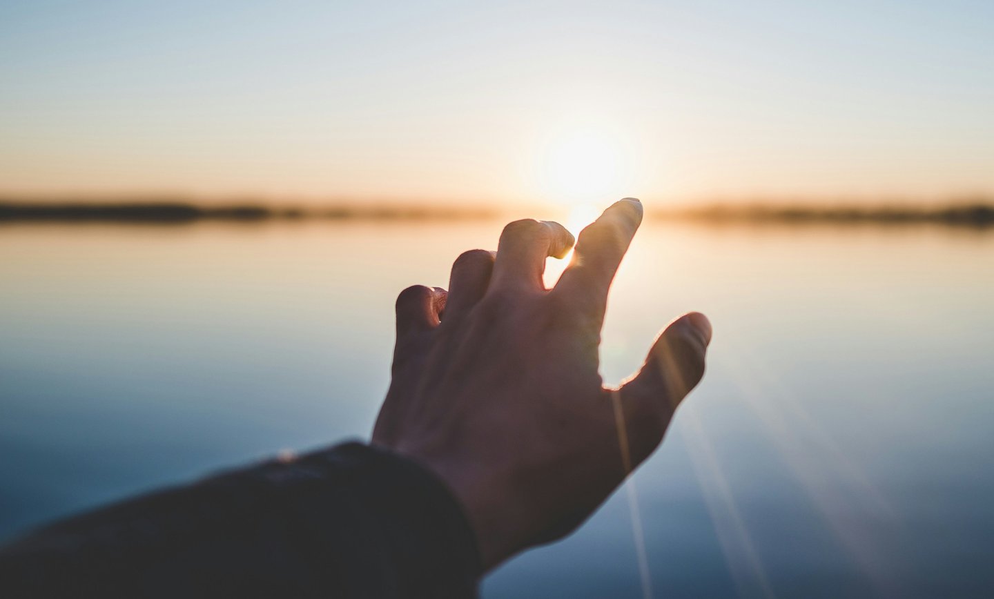 Hand reaching toward sunrise symbolizing hope and new beginnings after probate