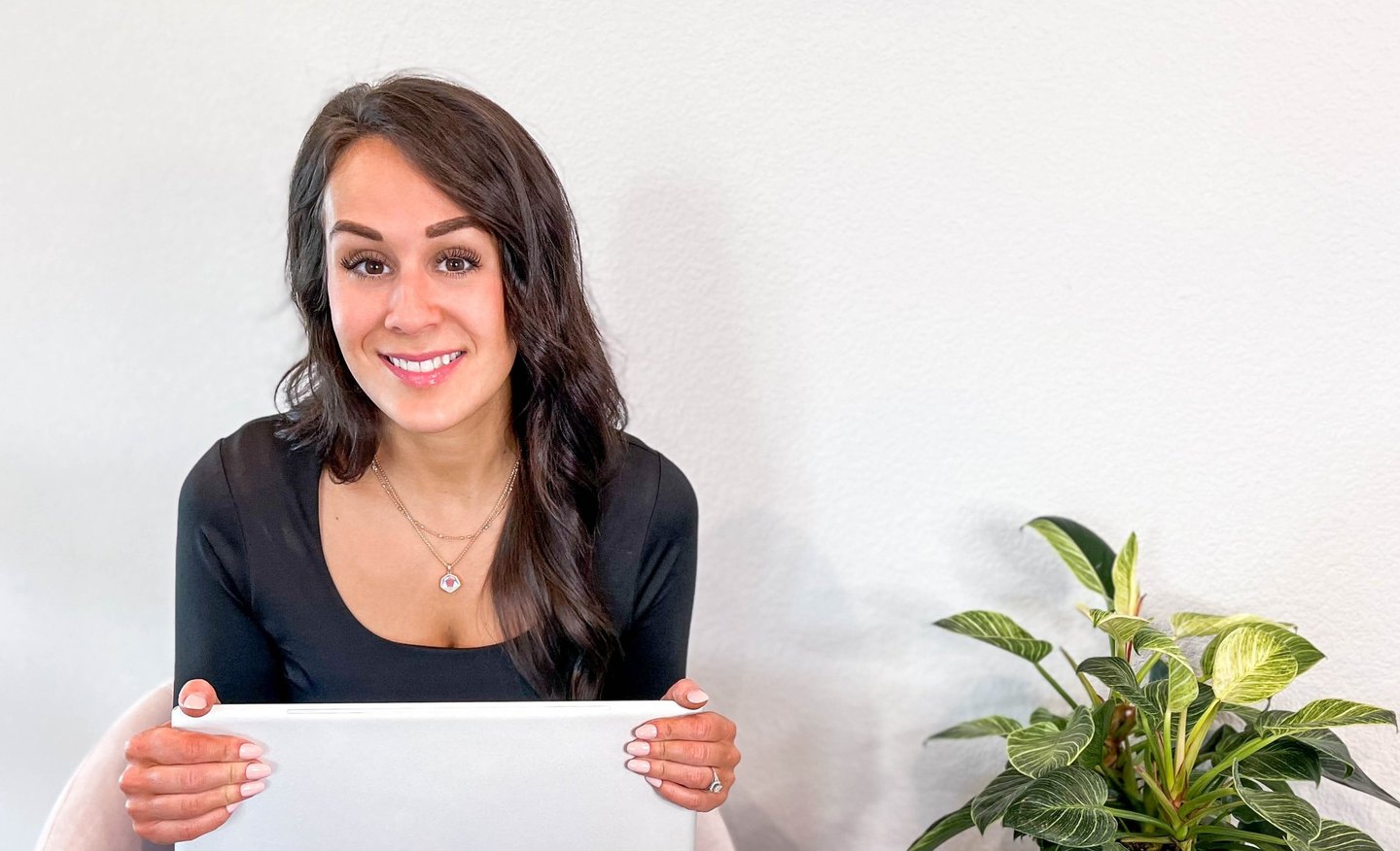Woman holding laptop and smiling