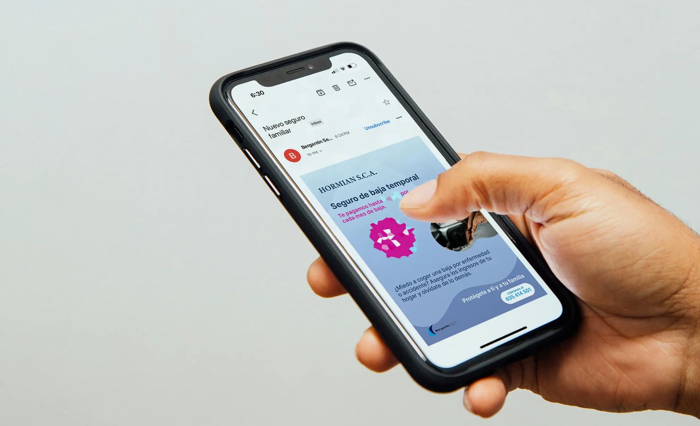 Mano usando un teléfono móvil viendo el cartel de Bergantin Insurance
