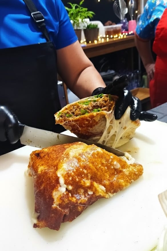 a person cutting a sandwich with a knife and knife