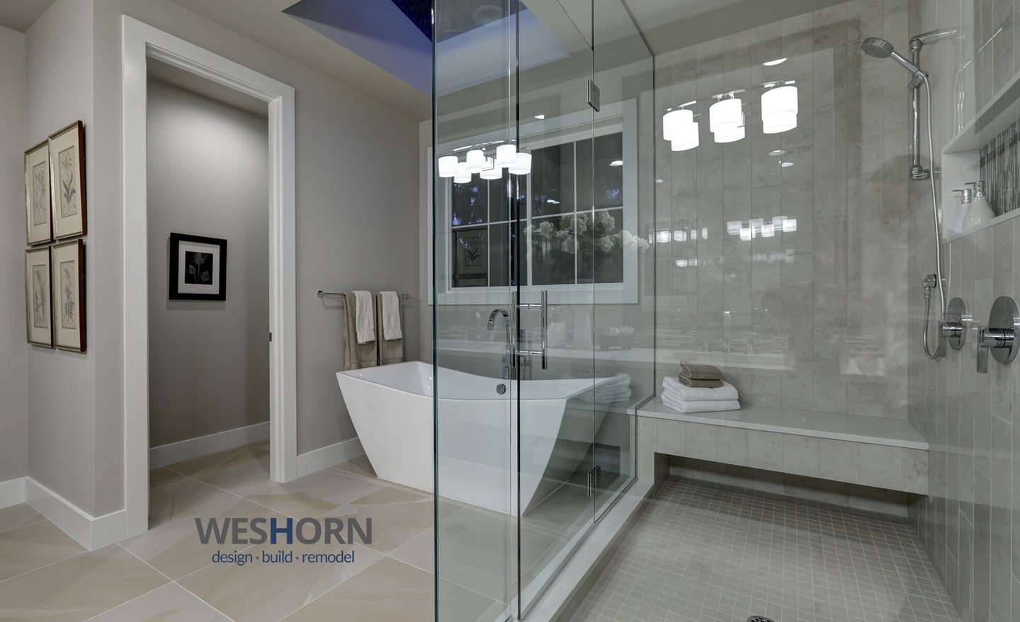 Modern master bathroom featuring a white freestanding soaking tub and glass walk-in shower with bench.