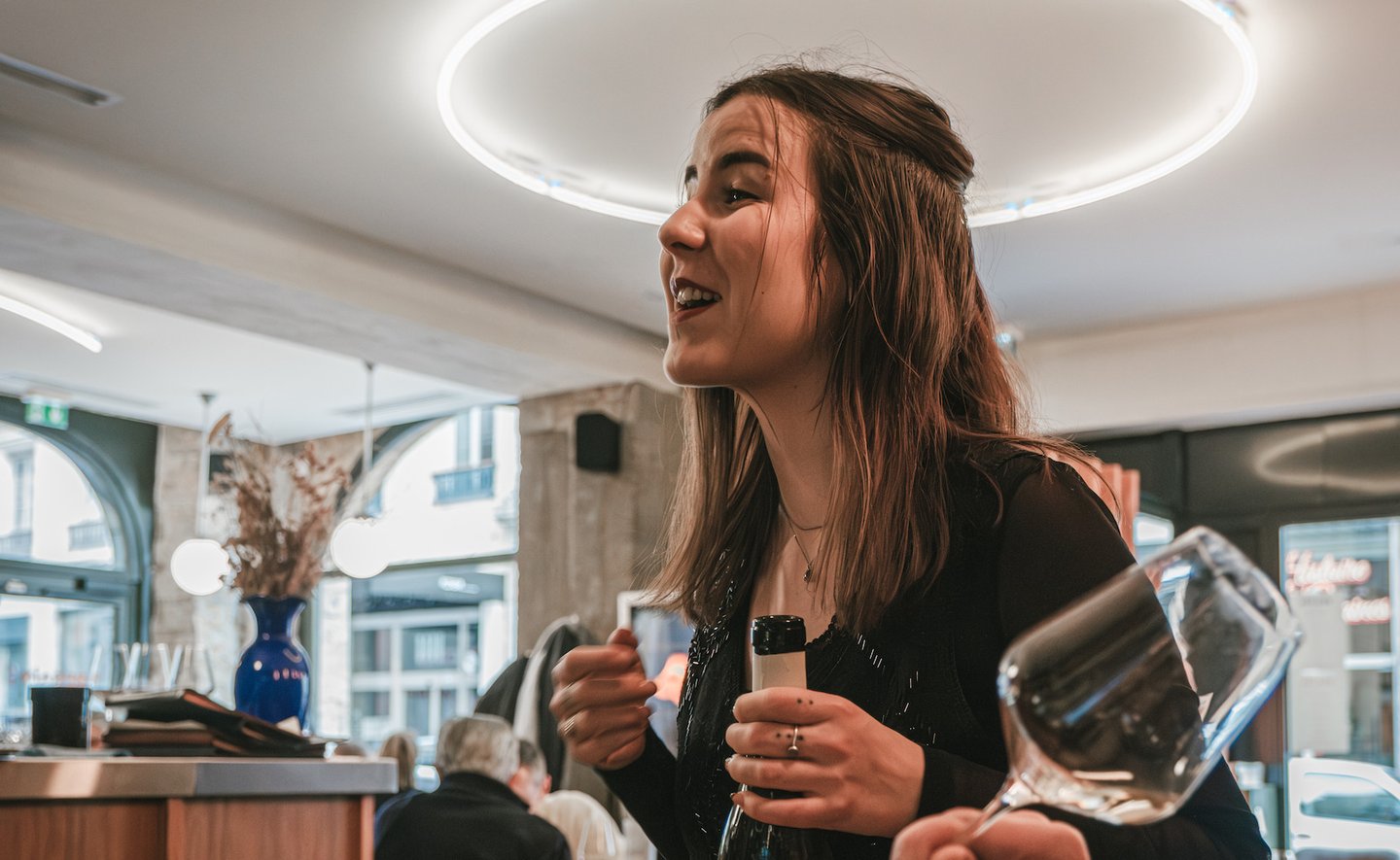 a woman is holding a wine glass in a restaurant