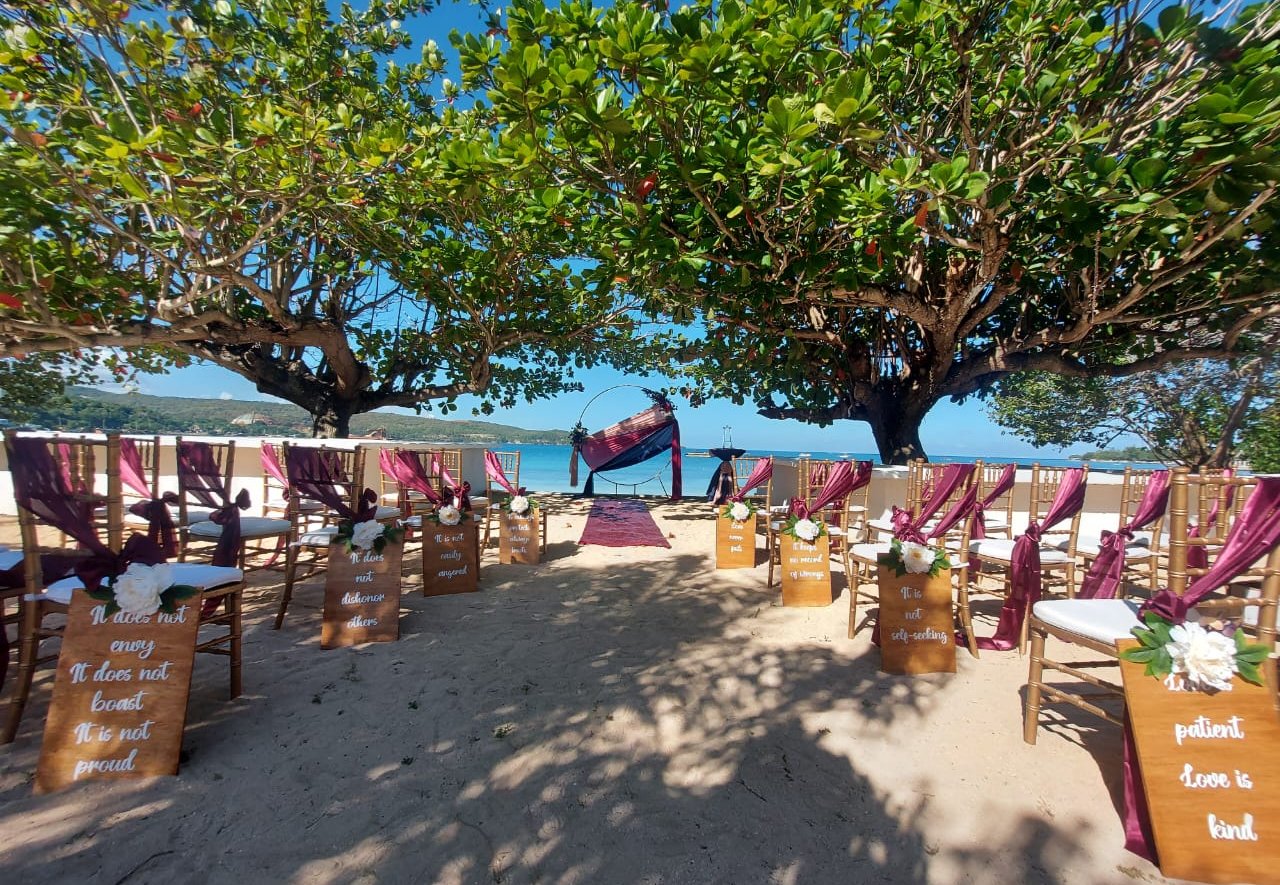 a beach wedding ceremony with aisle marker and chairs