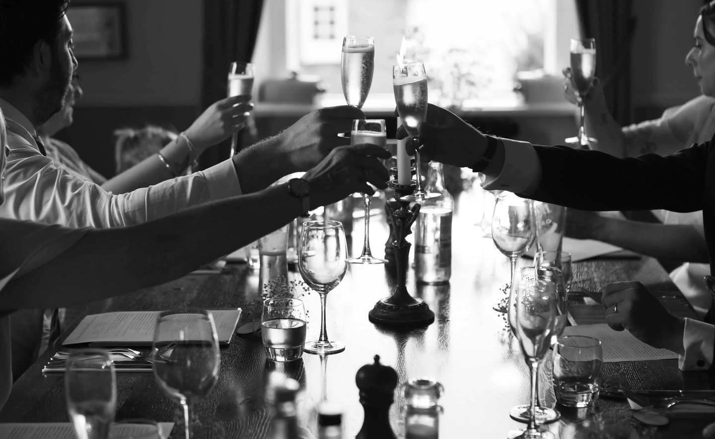 Classy black and white photo of wedding guests drinking champagne