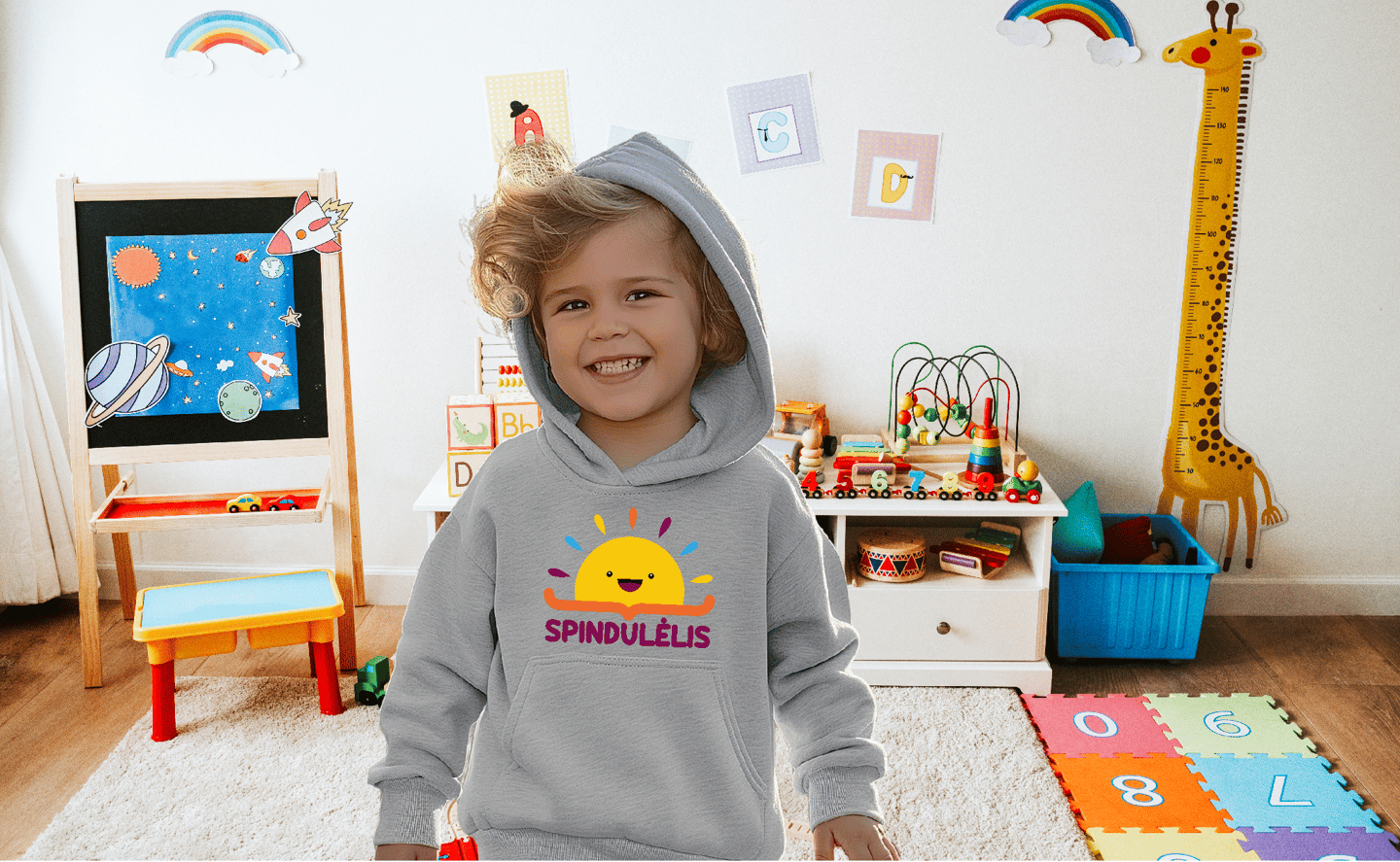 berniukas su dzemperiu ant kurio yra darzelio logotipas