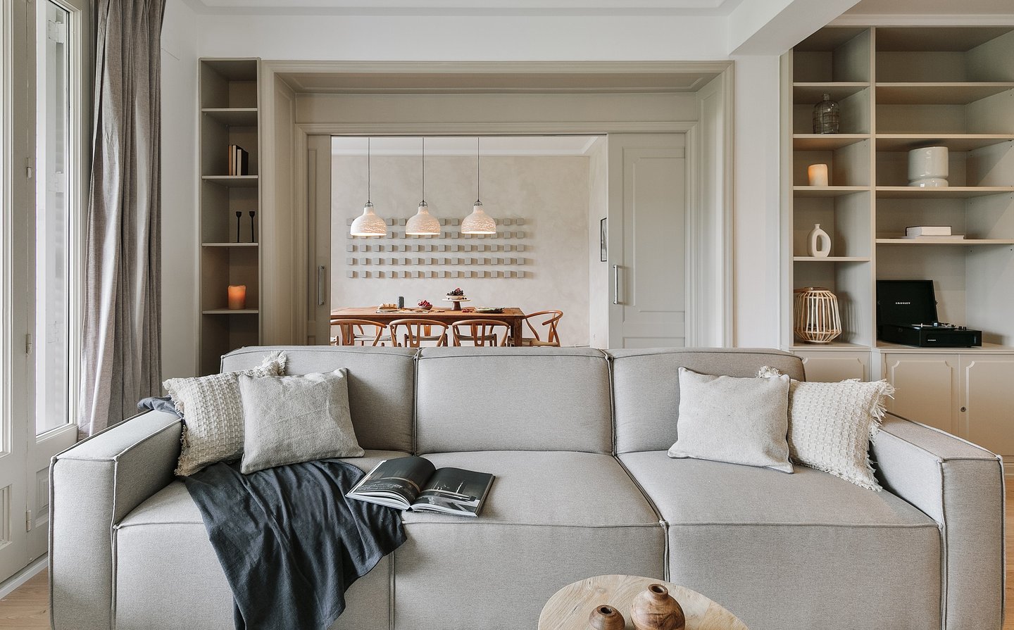 Elegant living room with bespoke wall installation, neutral tones by SAVIA interior design