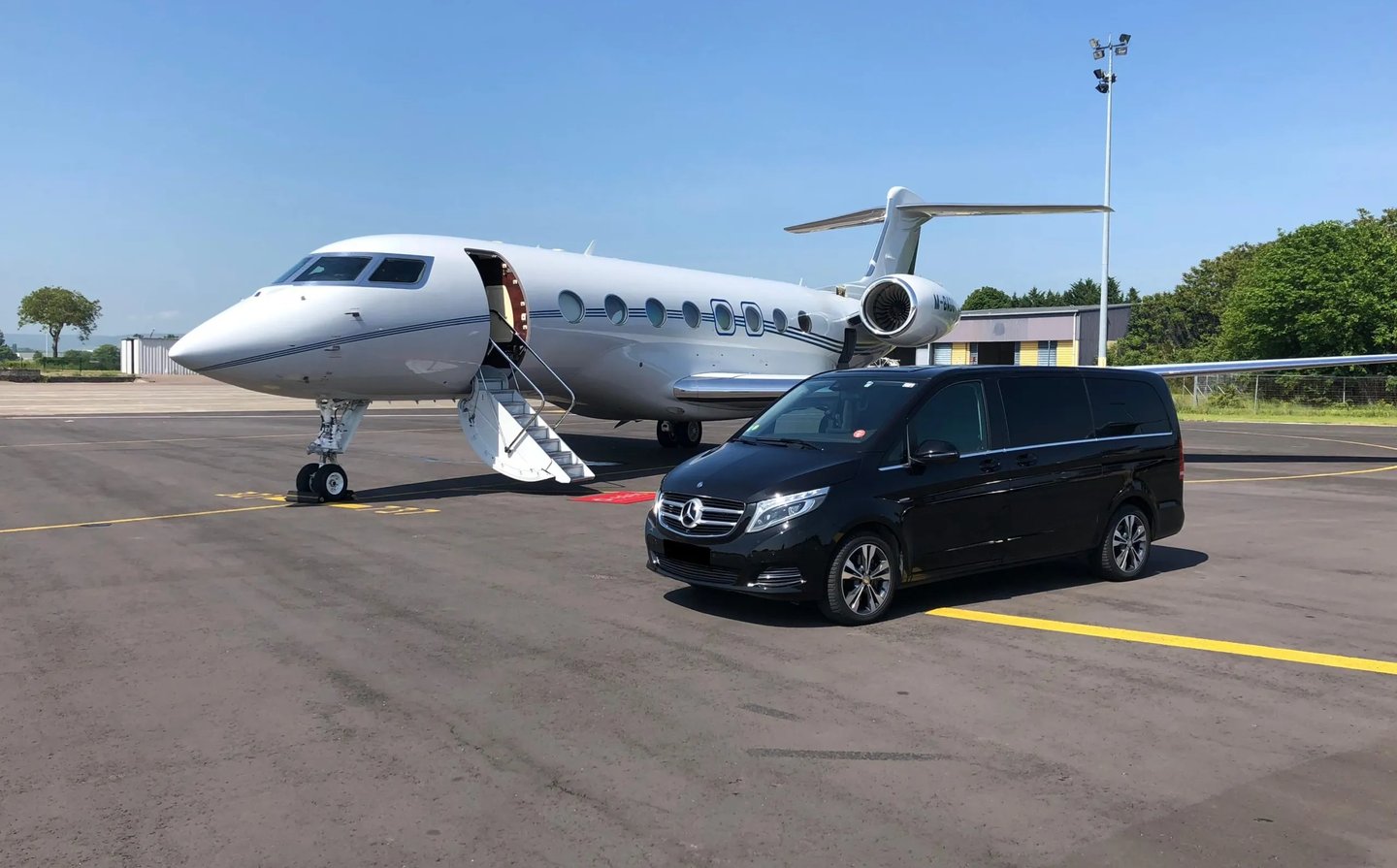 Mercedes Benz V-Class parked next to a Gulfstream G-IVSP on a private jet ramp