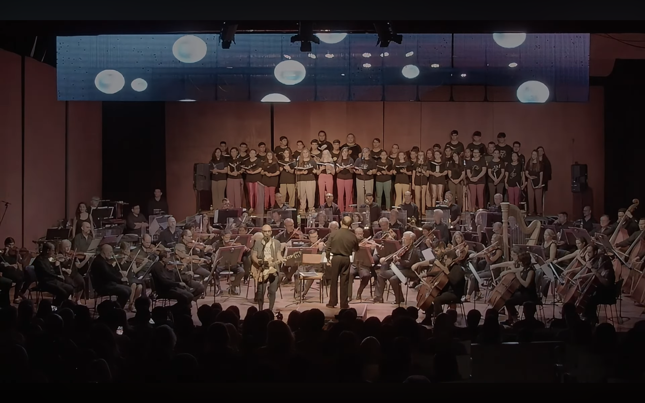 David De Mata with a conductor and orchestra in a concert hall