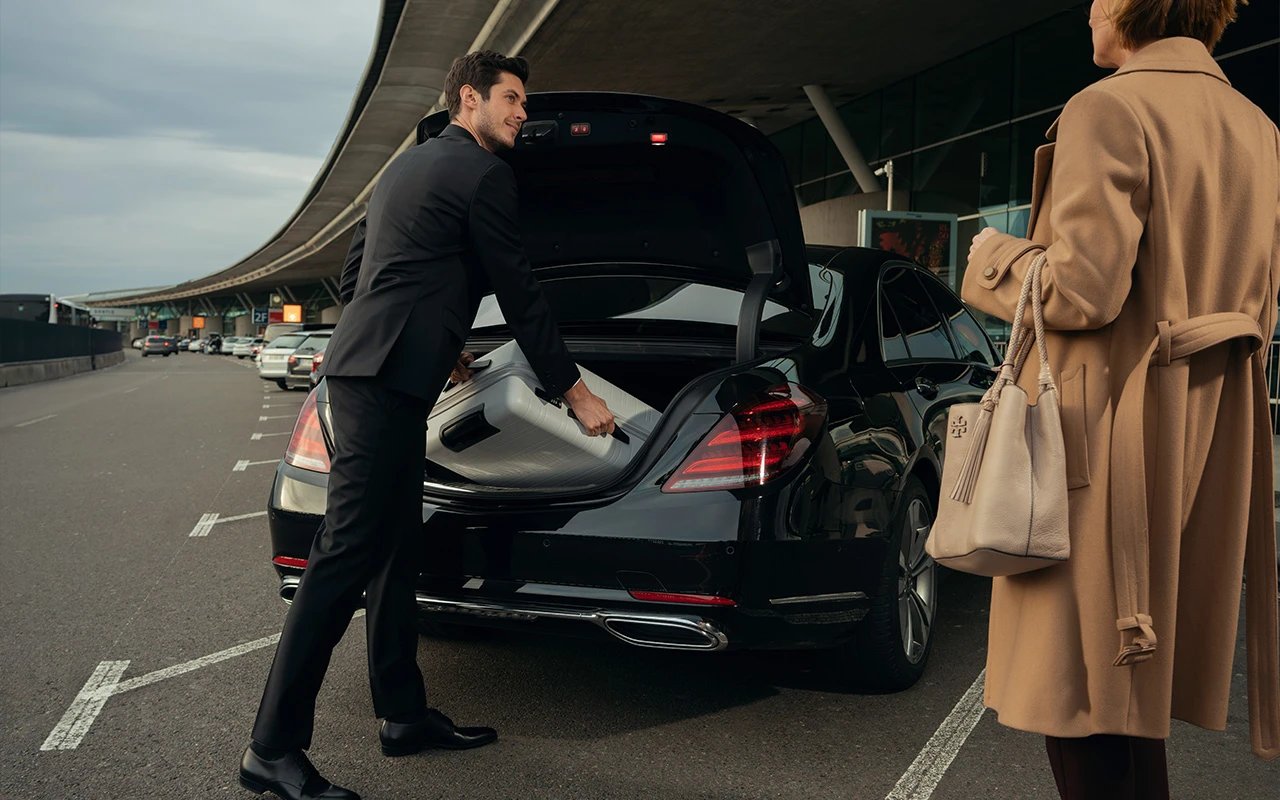 a man and woman standing in front of a car