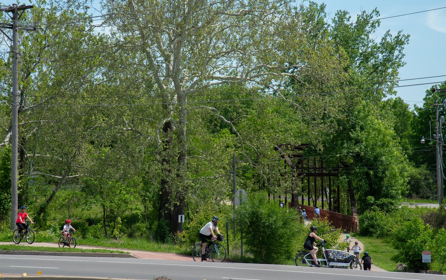 Lots of folks on bikes turning to go over a pedestrian bridge