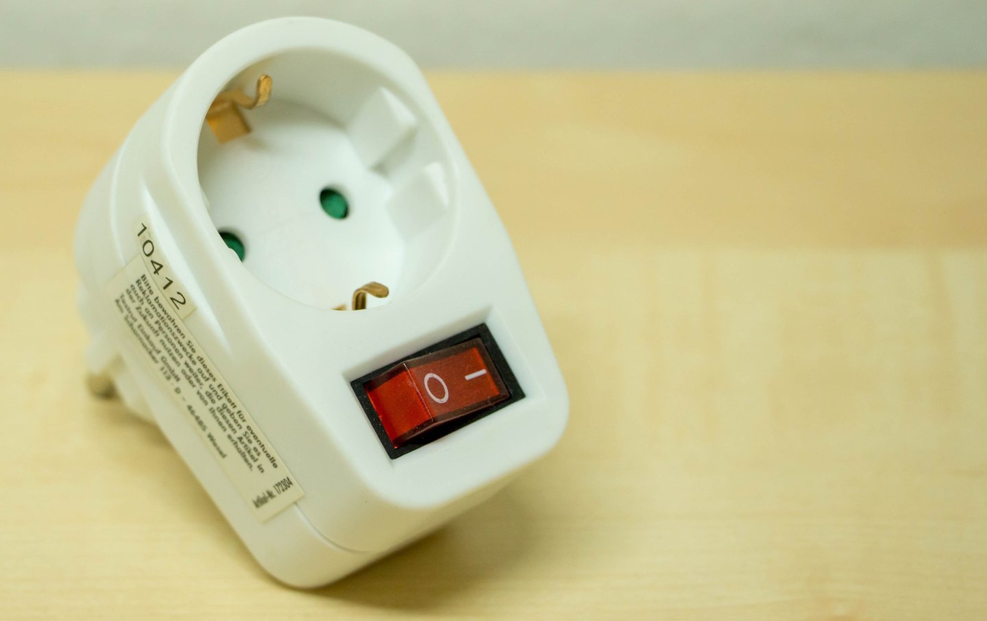 Universal travel power adapter charging multiple devices in international hotel room