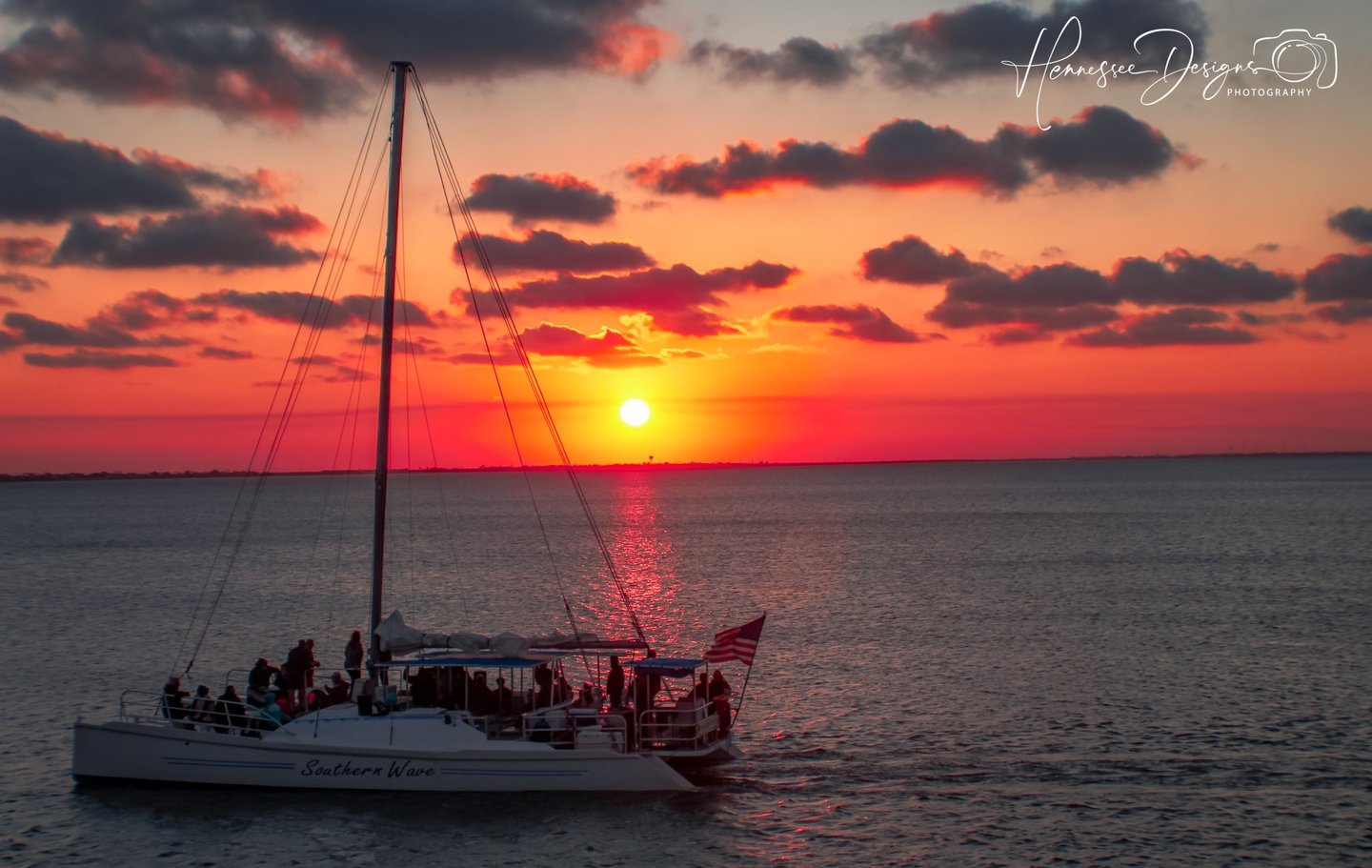 a sailboat in the ocean at sunset