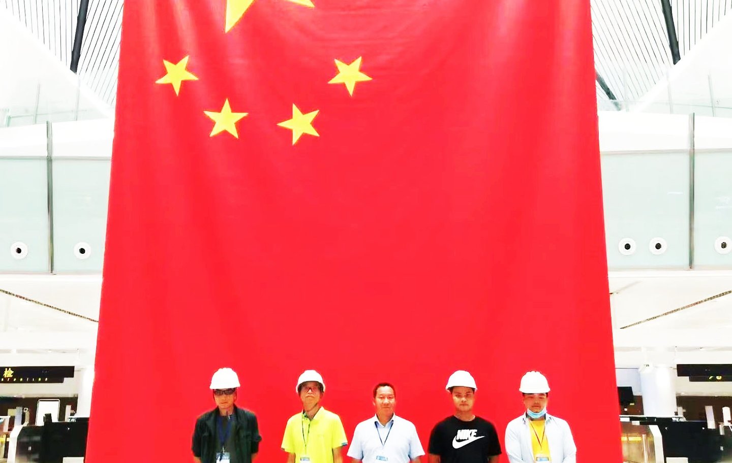 Team members installing a horizontal flag-raising system at Beijing Daxing International Airport