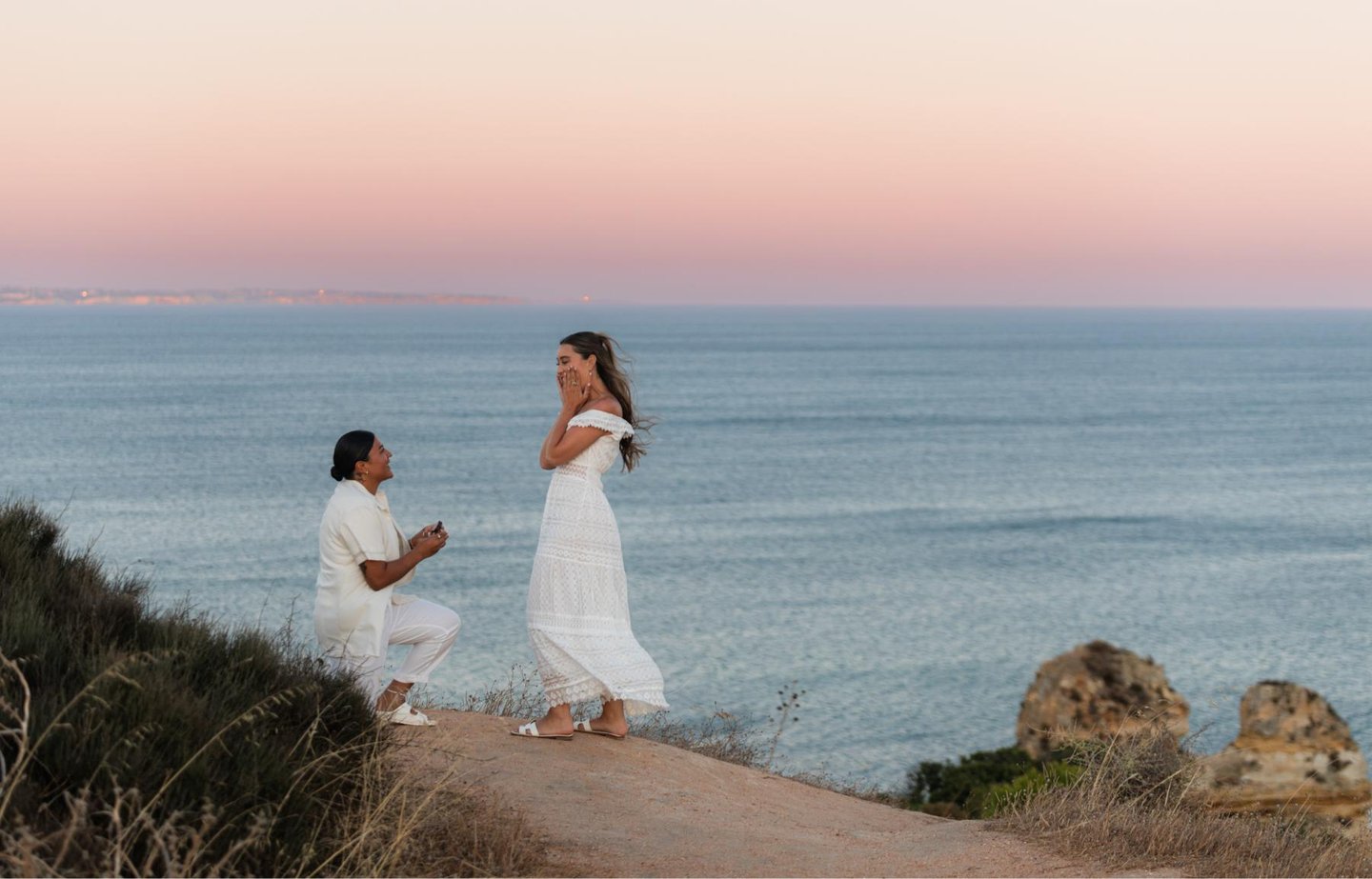a man proposing a woman on a cliff overlooking the ocean
