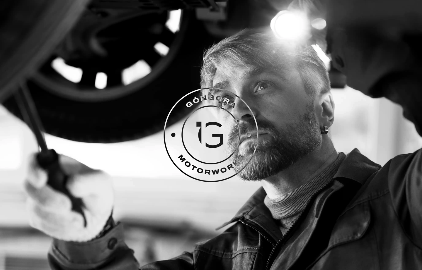 Foto de mecánico en blanco y negro con el logotipo de Góngora Motorworks en primer plano