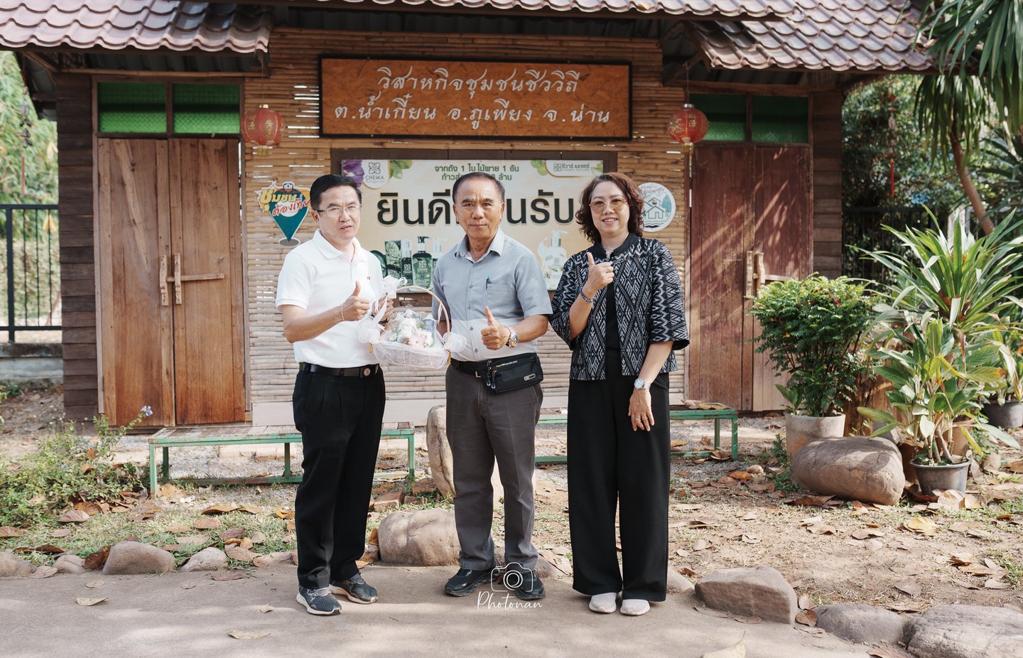 กลุ่มบุคคลถ่ายภาพหน้าป้ายชุมชนบ้านน้ำเกี๋ยน อำเภอภูเพียง จังหวัดน่าน บรรยากาศอบอุ่น วิถีชีวิตท้องถิ่