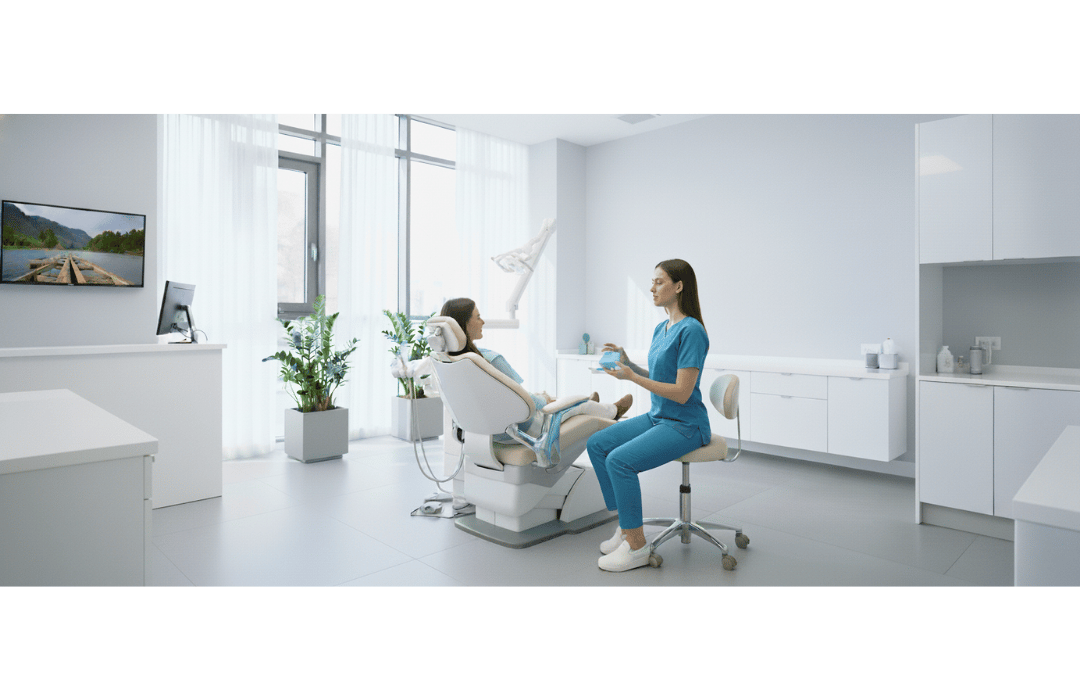 Una dentista con alineadores transparentes explicando el tratamiento a una paciente en el sillón