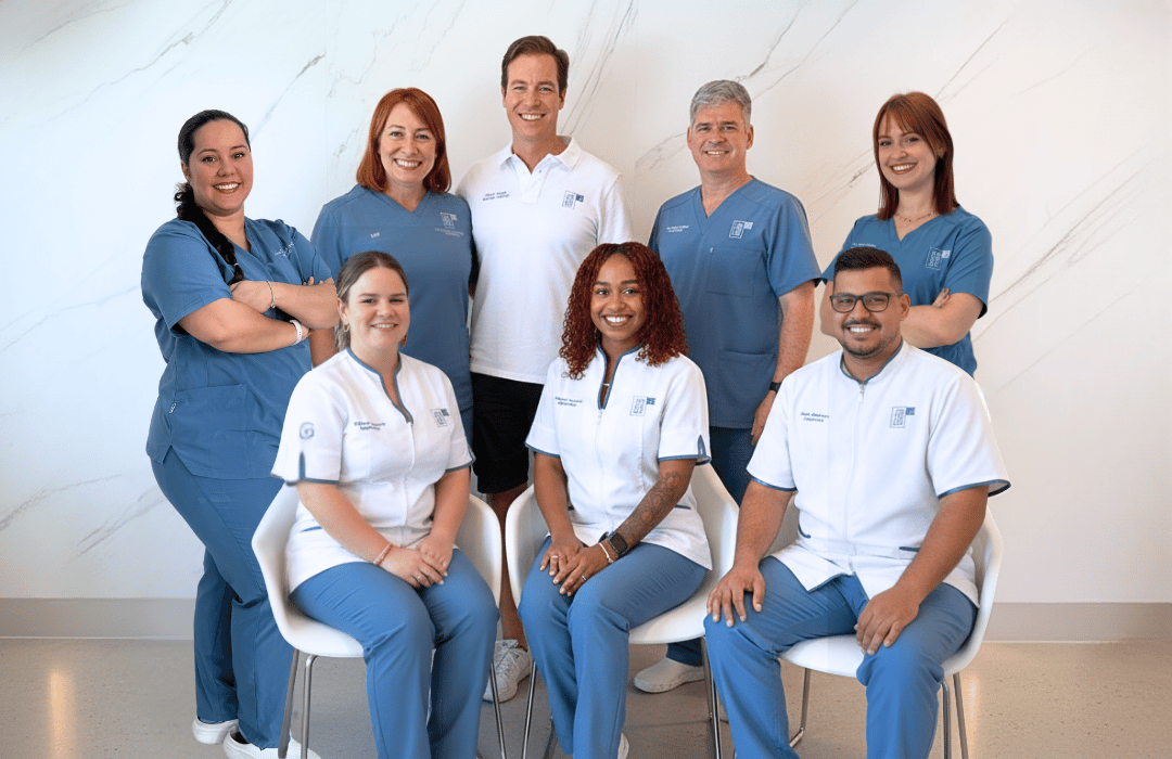 Equipo dental de la Clínica Bocarriba sonriendo a la cámara con algunos de pie y otros sentados