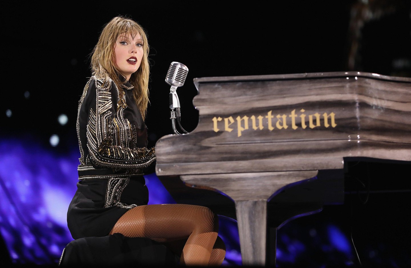 Taylor Swift performing at the piano during Reputation Stadium Tour 2018.