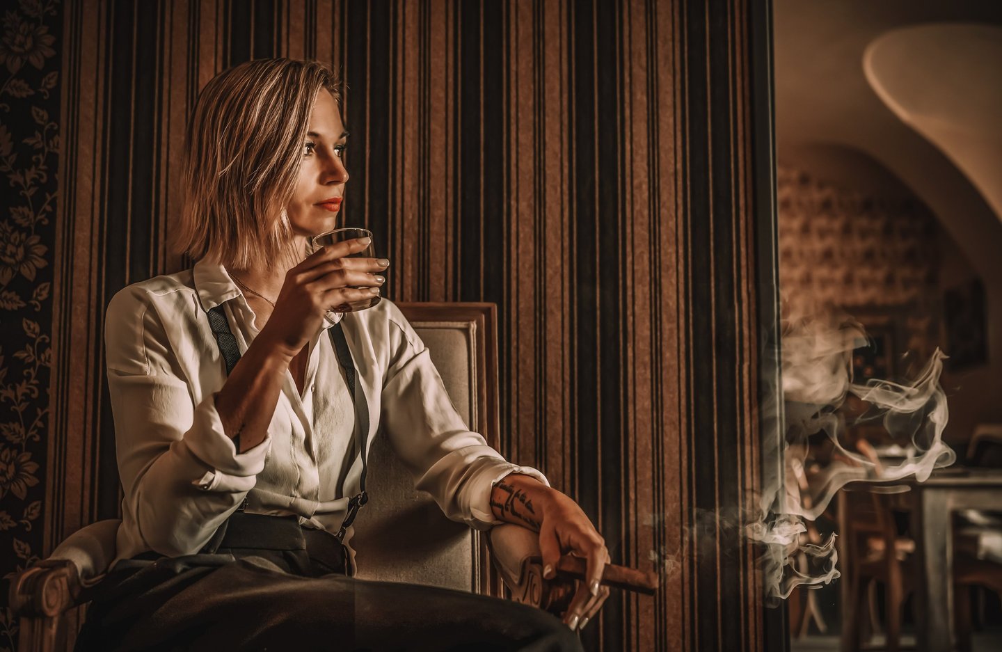 a woman sitting in a chair with a cigar and a cigar