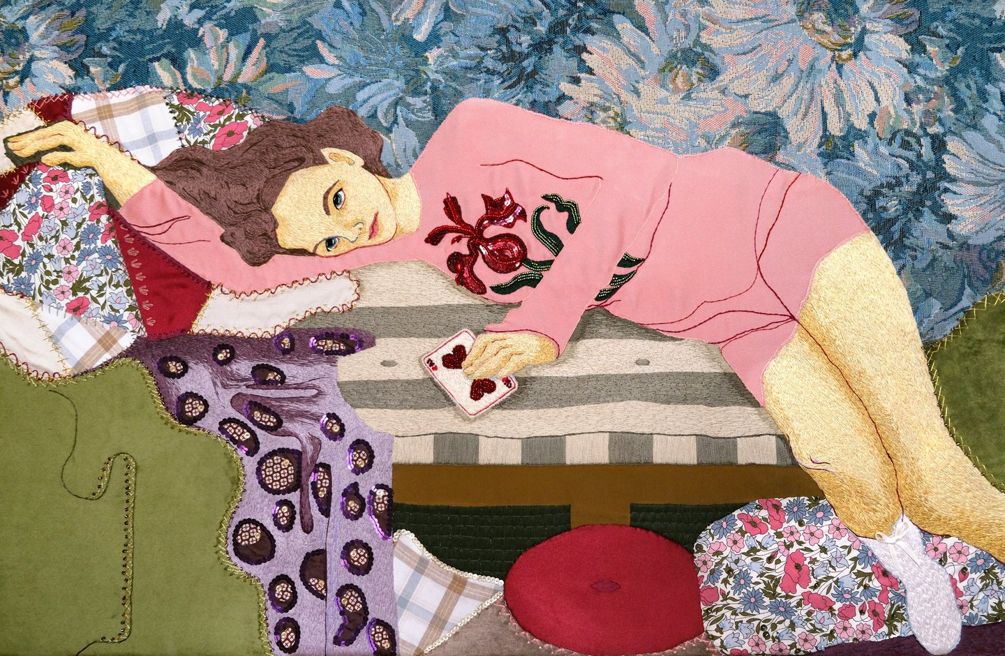 Textile art piece : a woman laying on a couch with a blanket