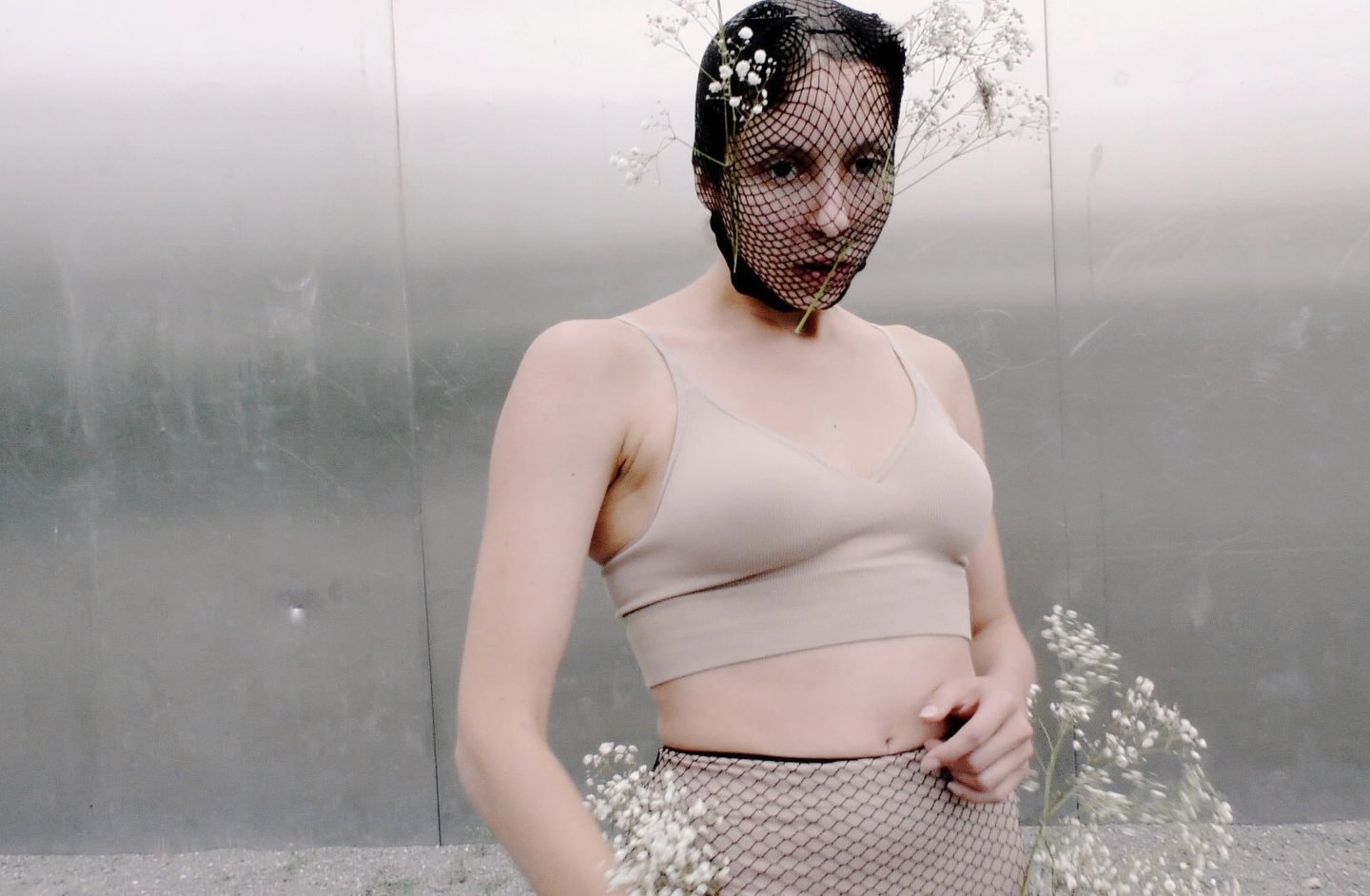 Performer standing in front of textured wall – Lingua Materna film still by Tina Bikic