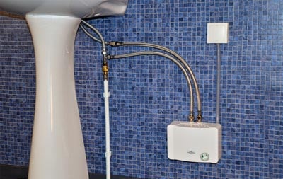 Chauffe-eau électrique sans réservoir installé sous un lavabo sur colonne à Yaoundé