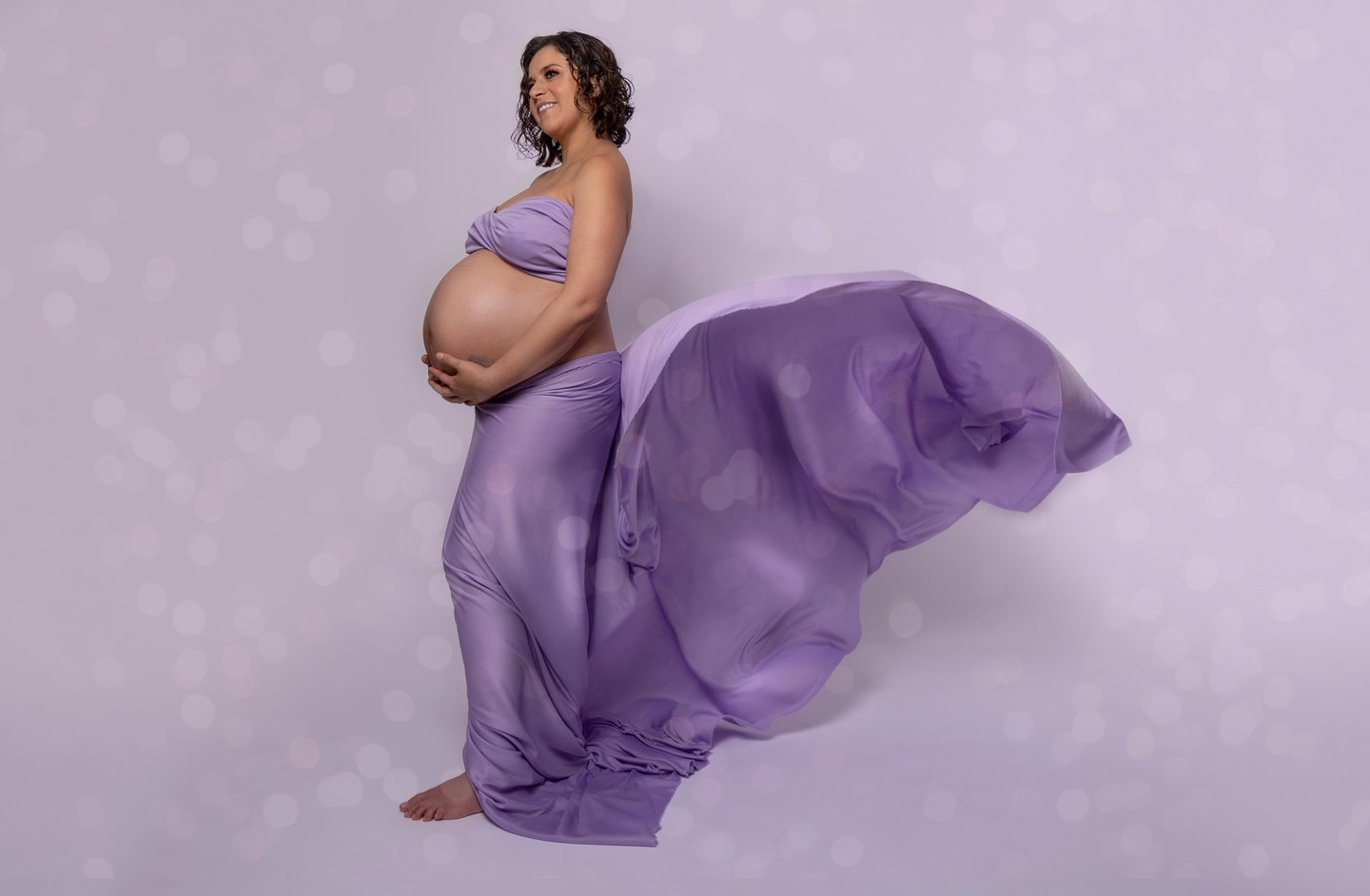 a pregnant woman in a purple dress with a flowing purple dress