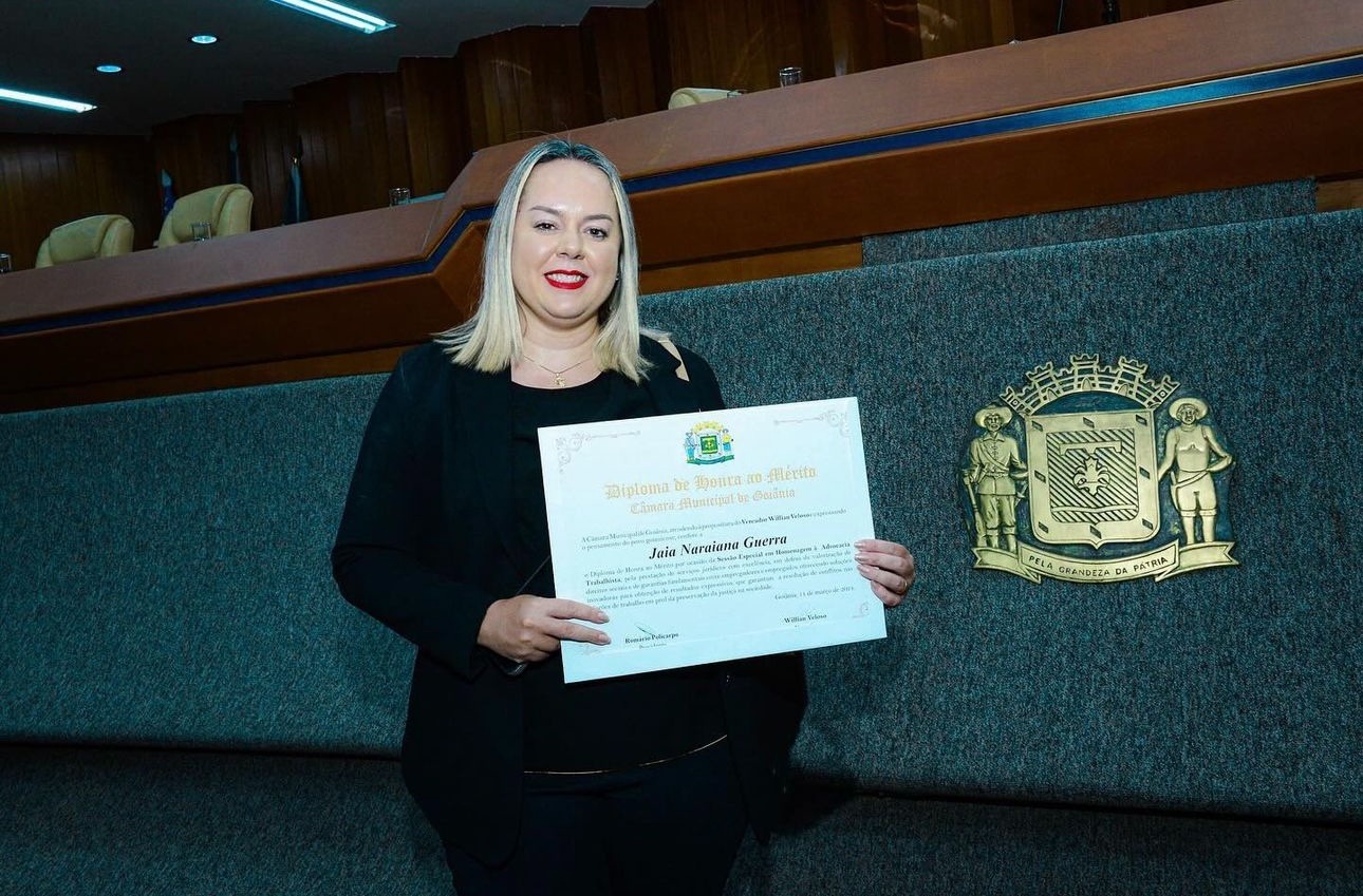 Uma mulher com um terno preto segurando um diploma