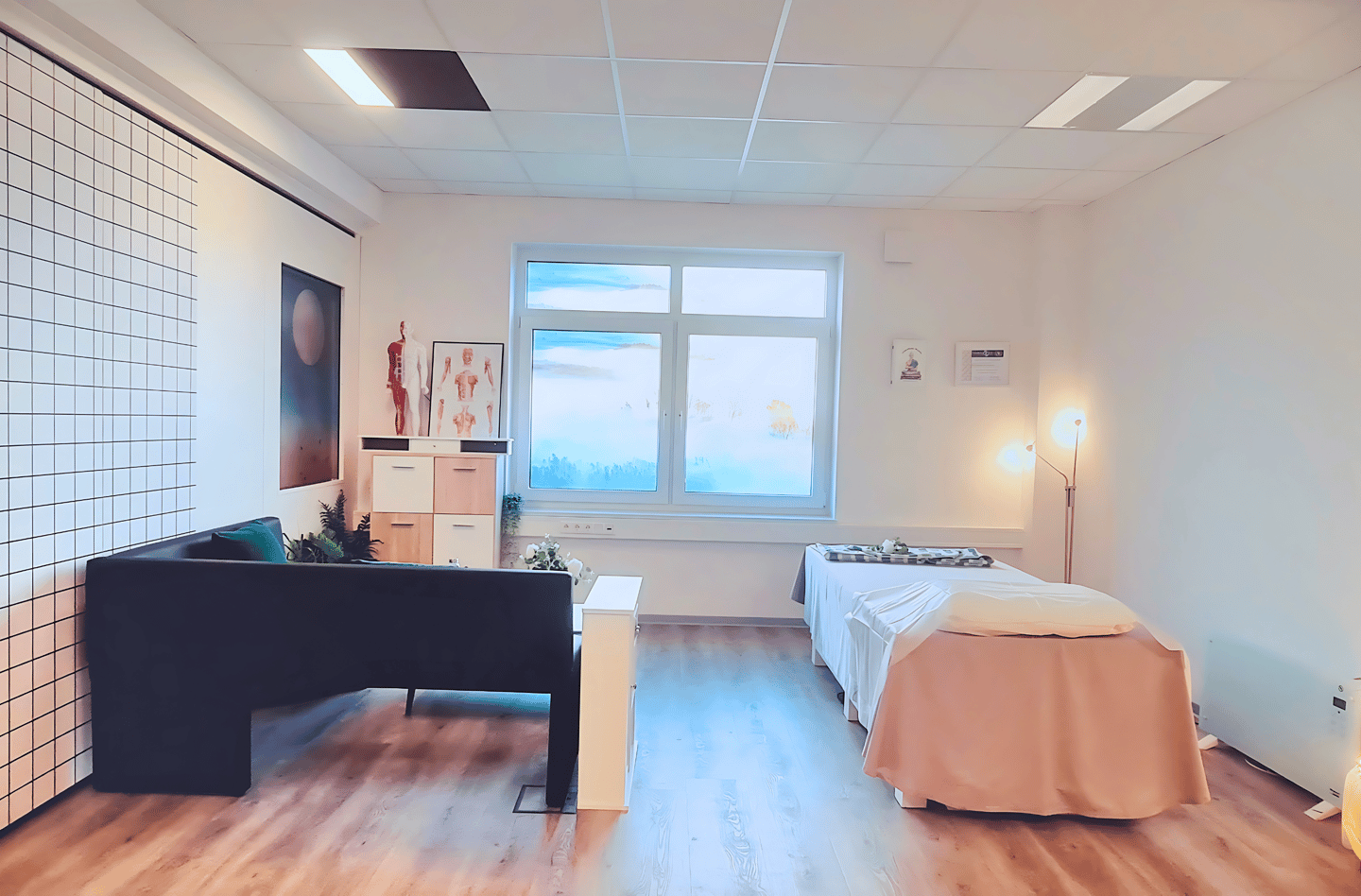 a room with a bed and a desk-Massage Raum Paderborn