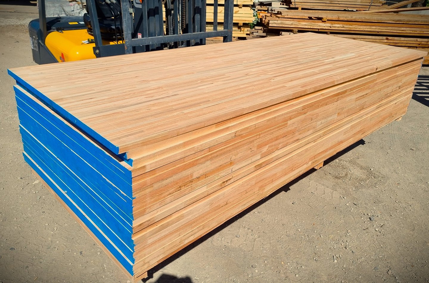 Una pila de láminas de madera contrachapada industrial con los bordes pintados de azul.